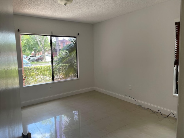 unfurnished room with a textured ceiling