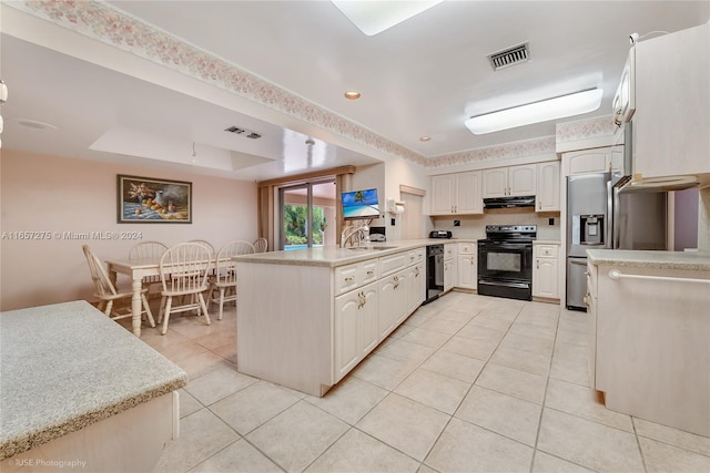 kitchen with black range with electric stovetop, sink, kitchen peninsula, a tray ceiling, and light tile patterned floors