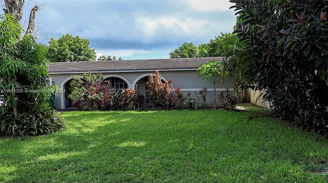 single story home featuring a front lawn