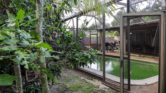 exterior space with glass enclosure and a fenced in pool