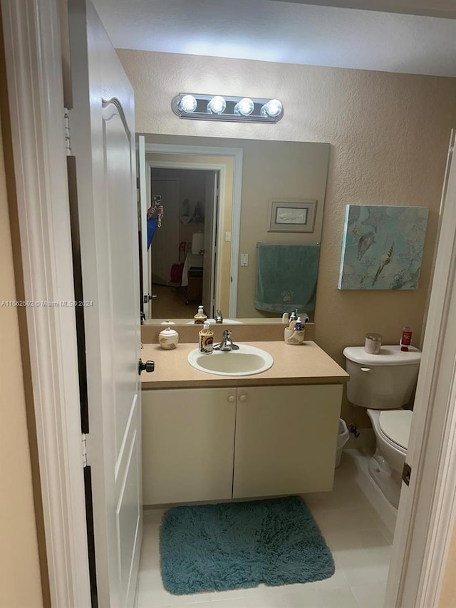 bathroom featuring tile patterned flooring, vanity, and toilet