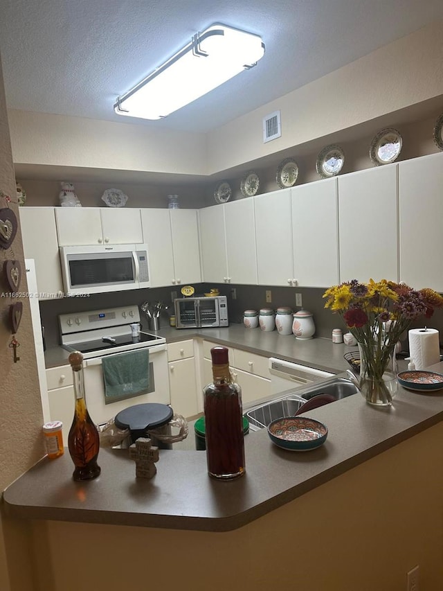 kitchen featuring white cabinetry, electric stove, and sink