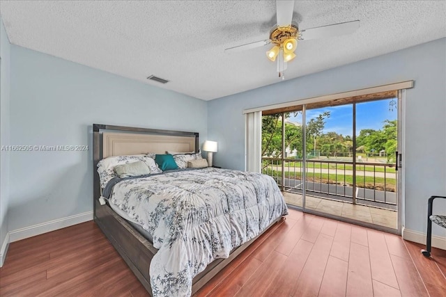 bedroom featuring a textured ceiling, wood-type flooring, access to outside, and ceiling fan