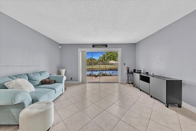 living room featuring a textured ceiling and light tile patterned floors