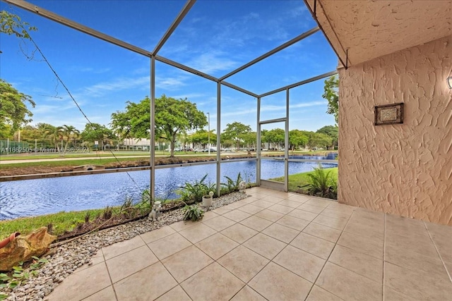 view of patio / terrace featuring a lanai and a water view