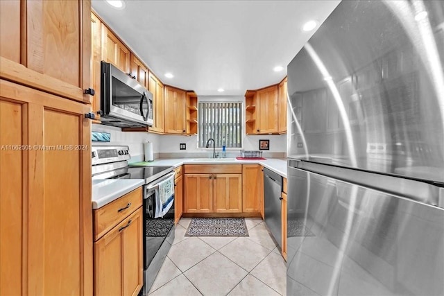 kitchen with stainless steel appliances, sink, and light tile patterned floors