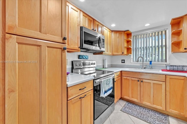 kitchen featuring light tile patterned flooring, stainless steel appliances, and sink