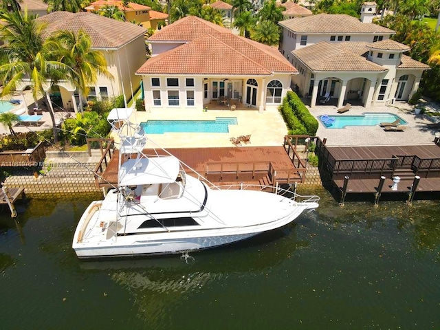 1486 Commodore Way, Hollywood, FL 33019 - back of house with a water view, a patio area, an outdoor pool, and a tile roof