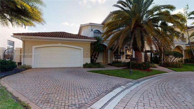 mediterranean / spanish-style house featuring a front yard and a garage