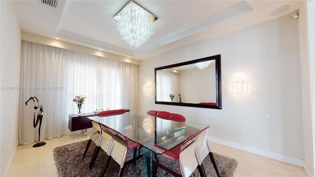 dining area with a tray ceiling, a chandelier, and ornamental molding