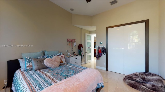 bedroom featuring ceiling fan, a closet, and light tile patterned floors