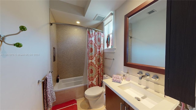 full bathroom with shower / tub combo with curtain, vanity, and toilet