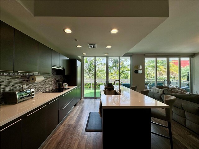 7751 NW 107th Ave Unit 205, Doral, FL 33178 - kitchen with decorative backsplash, visible vents, a sink, black electric stovetop, and open floor plan