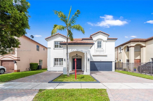 mediterranean / spanish home featuring a garage, central AC, and a front yard