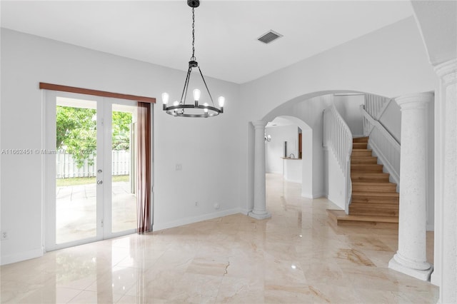 unfurnished dining area featuring french doors and decorative columns