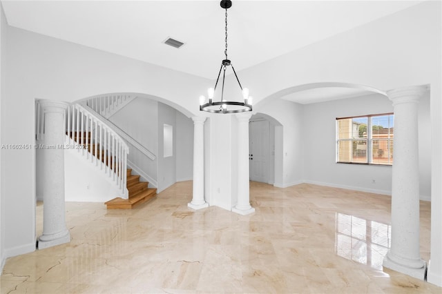 unfurnished dining area with ornate columns and a notable chandelier