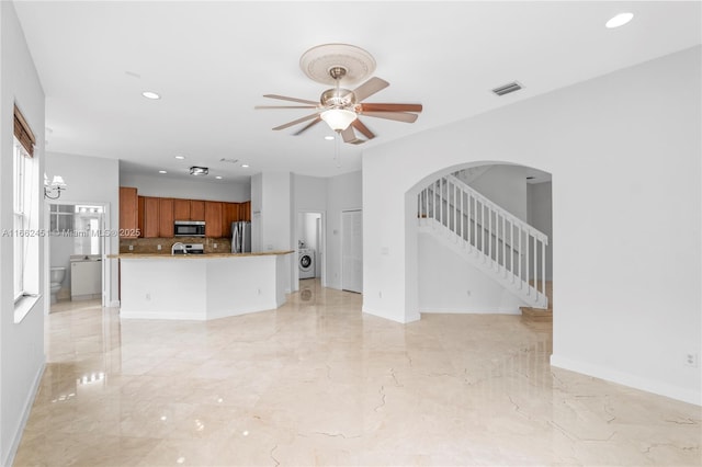 unfurnished living room with washer / clothes dryer and ceiling fan