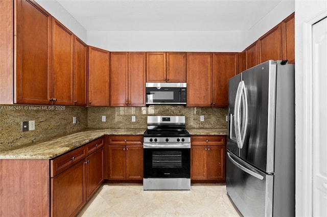 kitchen with light stone counters, backsplash, and stainless steel appliances