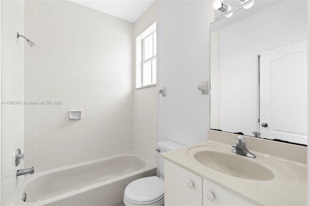 full bathroom featuring vanity, tiled shower / bath combo, and toilet