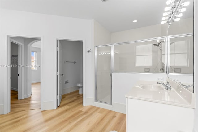 bathroom with vanity, wood-type flooring, toilet, and walk in shower