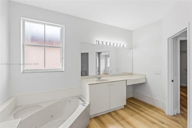 bathroom featuring vanity, a tub to relax in, and wood-type flooring