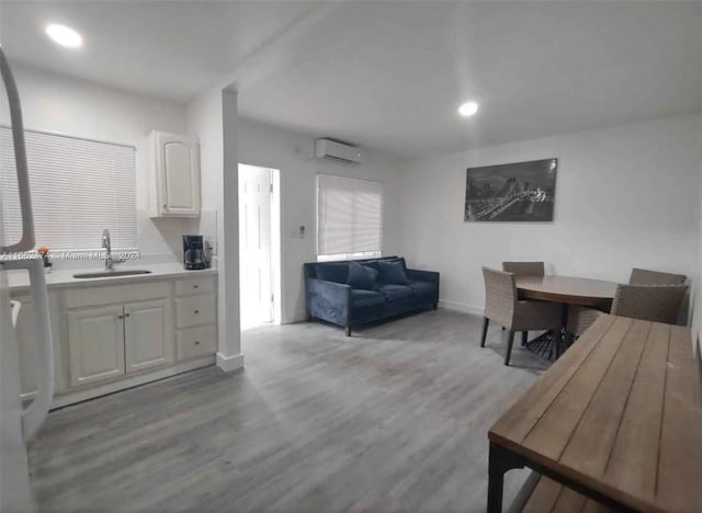 interior space with light hardwood / wood-style floors, an AC wall unit, and sink