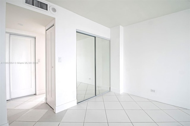 unfurnished bedroom featuring light tile patterned floors and a closet