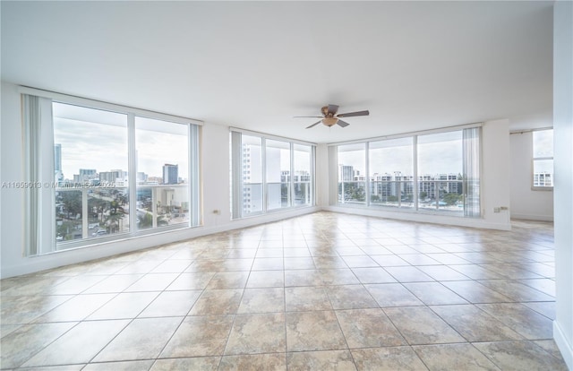 empty room with ceiling fan and a wealth of natural light