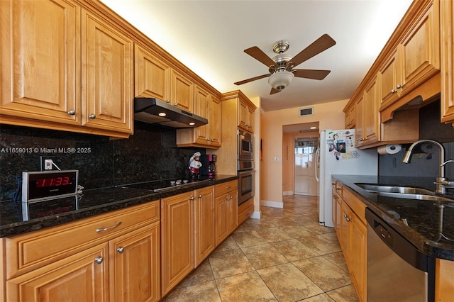 kitchen with ceiling fan, appliances with stainless steel finishes, backsplash, dark stone countertops, and sink