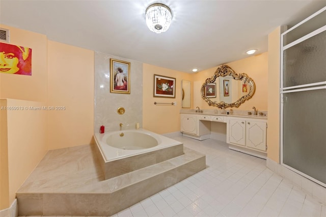 bathroom with tiled tub, tile patterned floors, and vanity