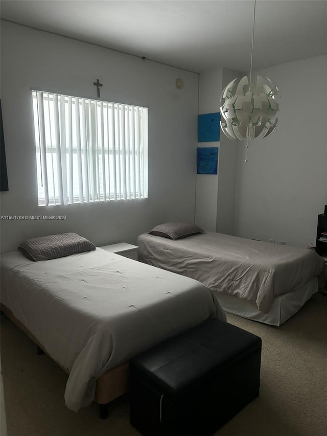 bedroom with carpet flooring and a chandelier