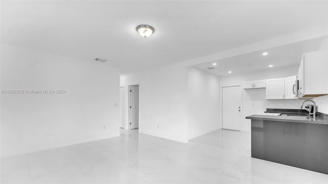 kitchen featuring kitchen peninsula, sink, and white cabinets