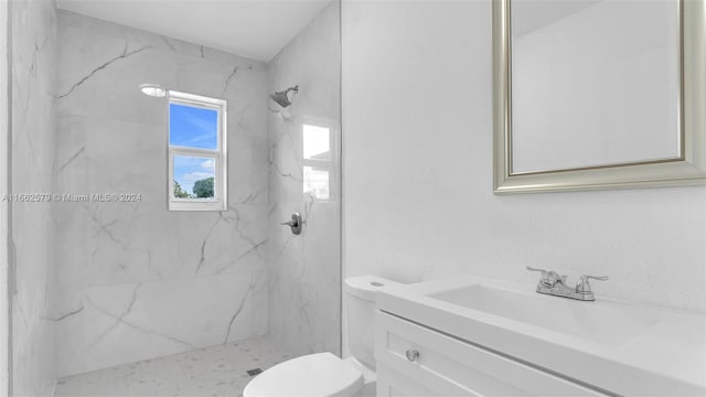 bathroom featuring tiled shower, vanity, and toilet