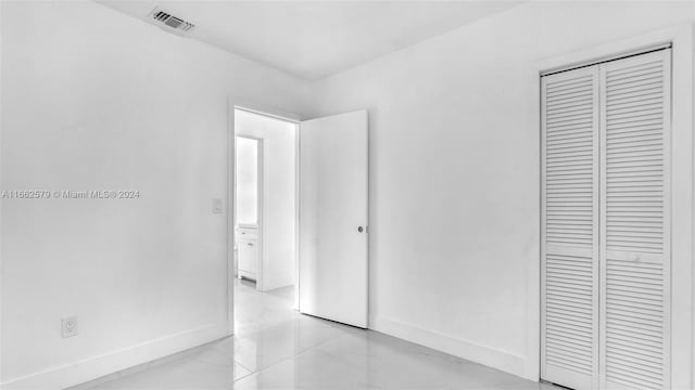 unfurnished bedroom featuring light tile patterned floors and a closet