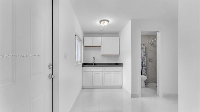 interior space featuring white cabinets and sink