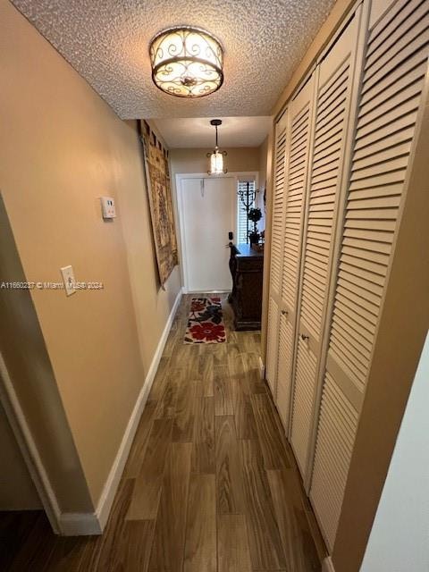 hall with a textured ceiling and hardwood / wood-style floors