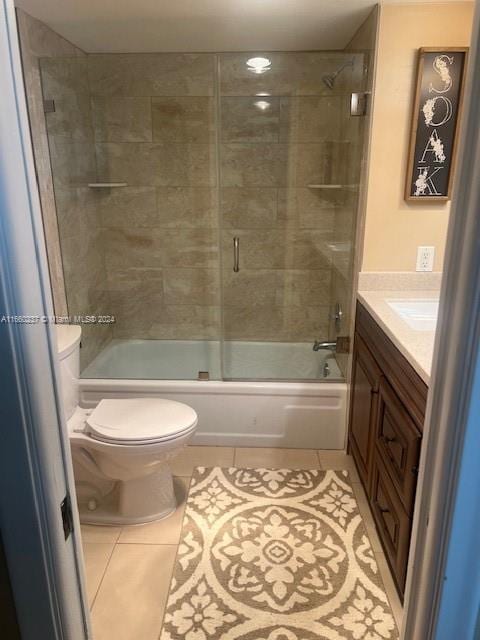 full bathroom featuring tile patterned flooring, shower / bath combination with glass door, vanity, and toilet