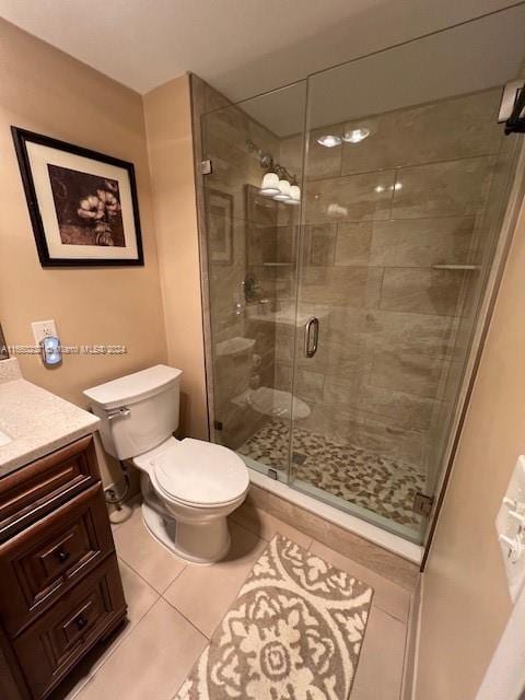 bathroom featuring walk in shower, vanity, toilet, and tile patterned floors