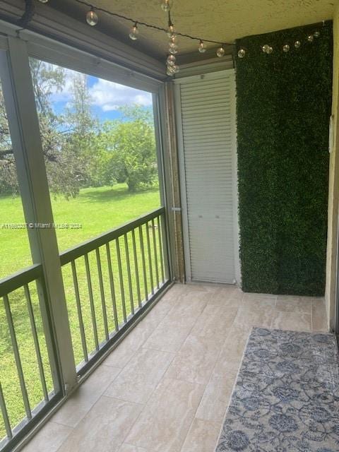 unfurnished sunroom featuring rail lighting