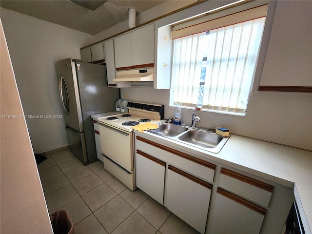 kitchen with white cabinetry, stainless steel refrigerator, light tile patterned floors, white range with electric cooktop, and sink