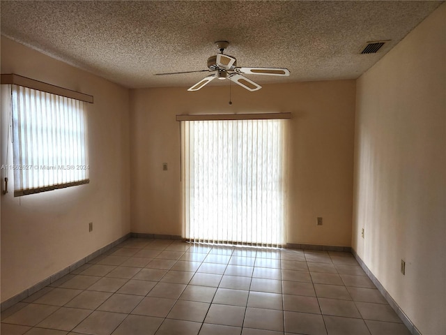 spare room with ceiling fan, a textured ceiling, and light tile patterned floors