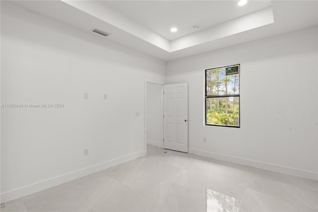 unfurnished room with a raised ceiling