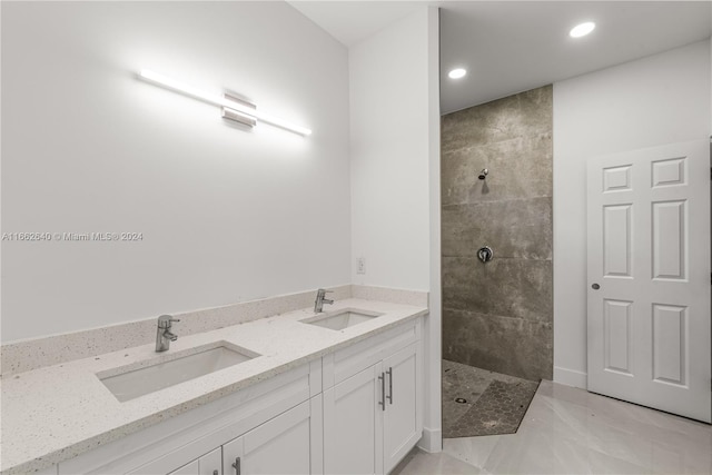 bathroom featuring tiled shower and vanity