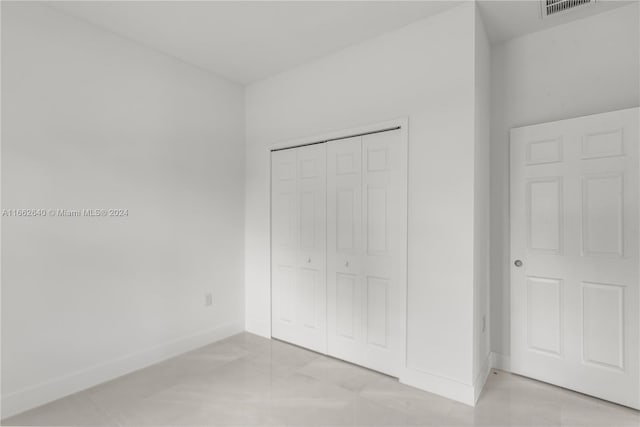 unfurnished bedroom with a closet and light tile patterned floors