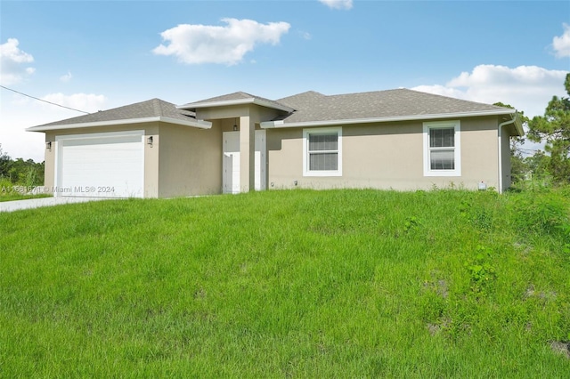 view of front of property featuring a garage and a front lawn