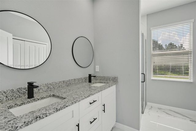 bathroom with a healthy amount of sunlight, vanity, and a shower with door