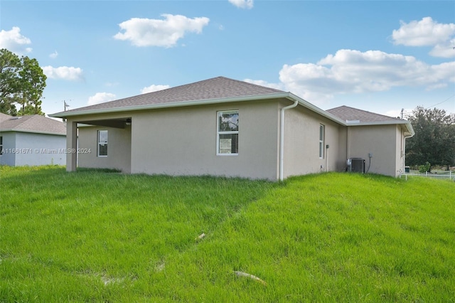 view of side of home featuring a lawn and central air condition unit