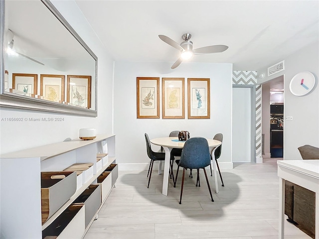 dining space featuring light wood-type flooring and ceiling fan