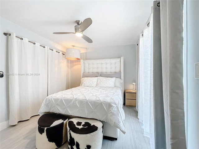 bedroom featuring light wood-style flooring, baseboards, and ceiling fan