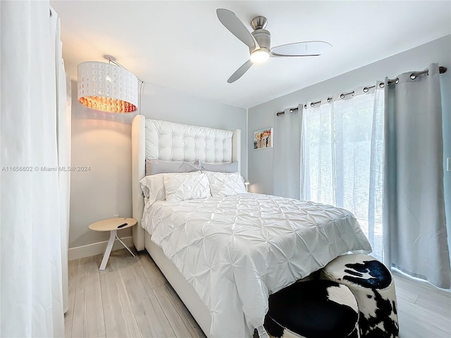 bedroom featuring light wood finished floors, baseboards, and a ceiling fan